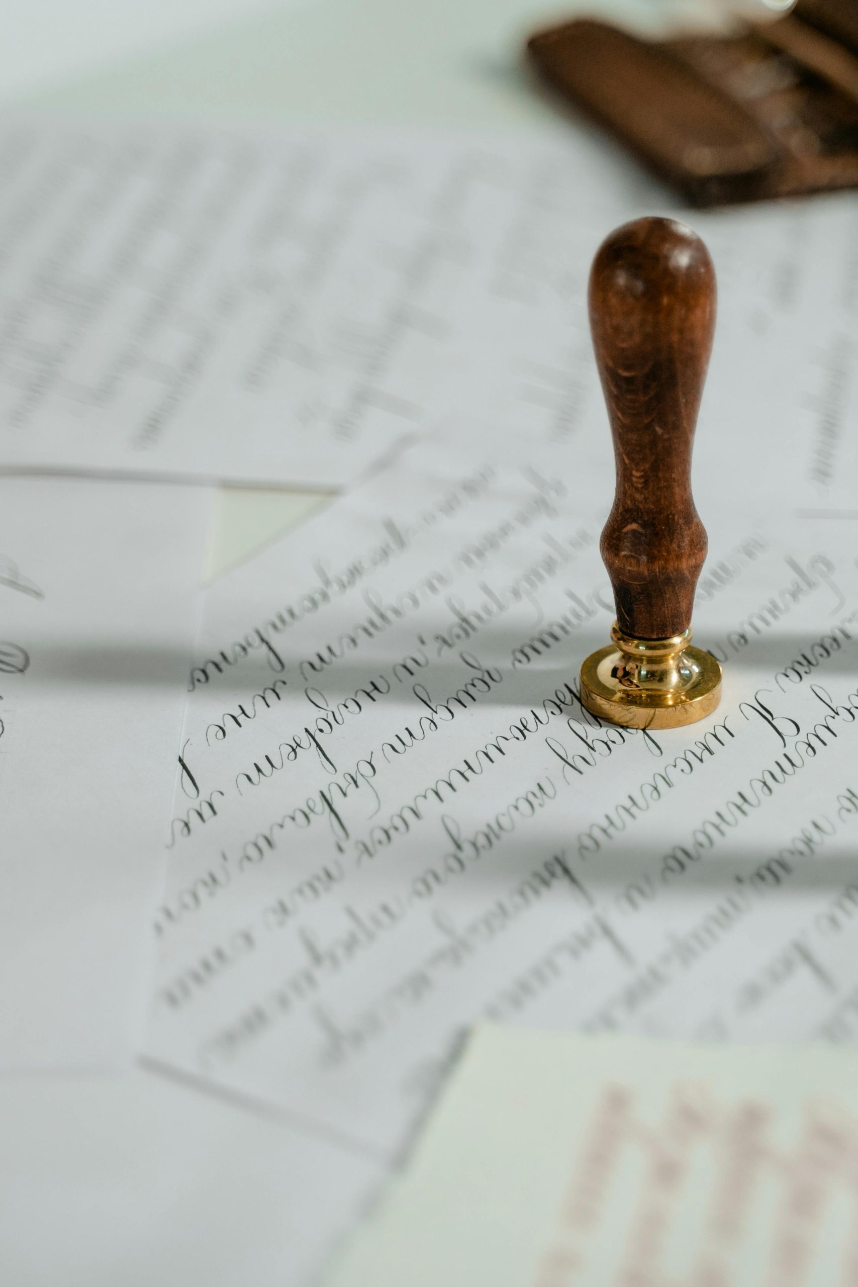 Vintage calligraphy papers with a wooden wax seal stamp, embodying timeless elegance.